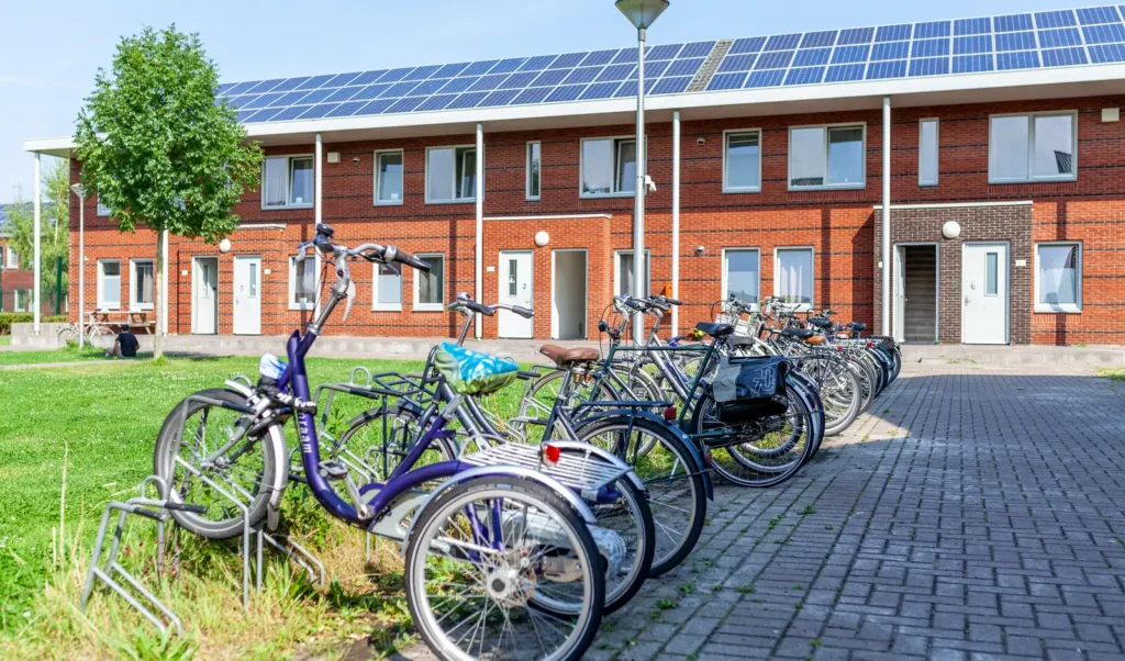 Fietsenstalling bij COA-woningen in Ter Apel met zonnepanelen op het dak, beeld bij het artikel over de tender energiemanagement voor COA